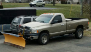 A truck with a plow in the back of it.